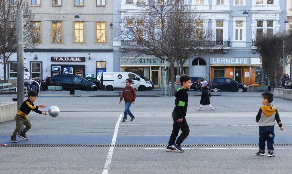 Children playing with a ball in a square