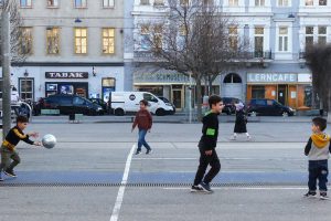 Kinder spielen auf einem Platz mit einem Ball