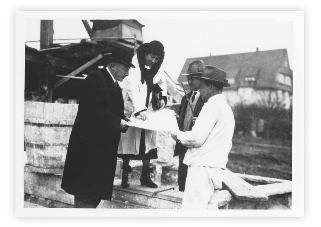 schwarz-weiß Foto mit 3 Männern mit Hut und einer Frau mit Hut