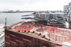 Hafengebiet in einer Stadt mit rot gefärbtem Gebäude im Vordergrund