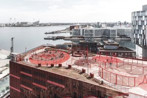 Harbour area in a city with red-coloured building in the foreground