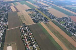 Blick aus der Vogelperspektive auf Felder und Siedlungen mit Häusern dazwischen