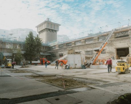 Construction site with various vehicles and a tower in the background