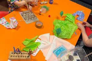orange table where children can make things with paper, scissors and adhesive tape