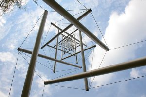 ropes with poles hanging in the air, above them the sky with clouds