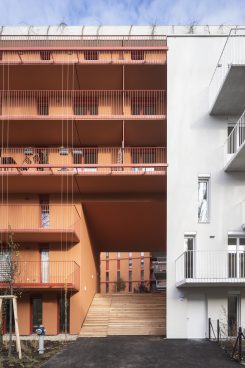 Multi-storey house in the colours white and brick red with balconies
