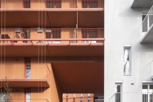 Multi-storey house in the colours white and brick red with balconies