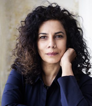 Woman with dark curly hair and a dark blue top
