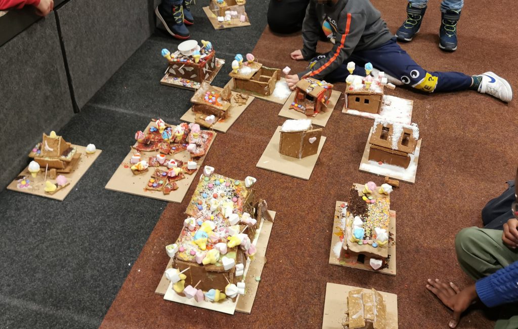 aus Lebkuchen geformte Häuschen mit viel bunten Zuckerl darauf