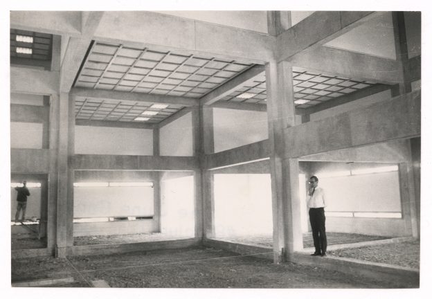 s/w Foto von einem Mann in einem Raum gebildet aus Betonbalken