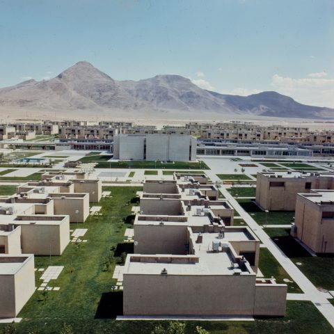 a cluster of buildings in the middle of a desert-like landscape