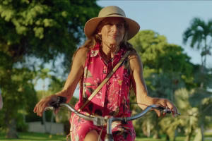 drei Frauen fahren auf einem Fahrrad, die Frau in der Mitte trägt einen Sonnenhut