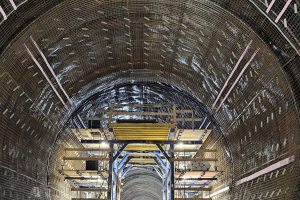 Tunnelbaustelle mit Baugerüst, Wasser und Schlauch der am Boden liegt