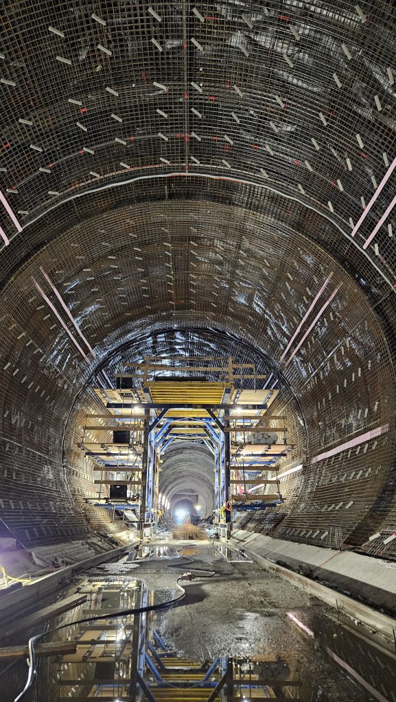 Tunnelbaustelle mit Baugerüst, Wasser und Schlauch der am Boden liegt