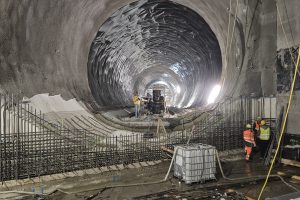 Baustelle in riesigem Tunnel mit Bauarbeitern
